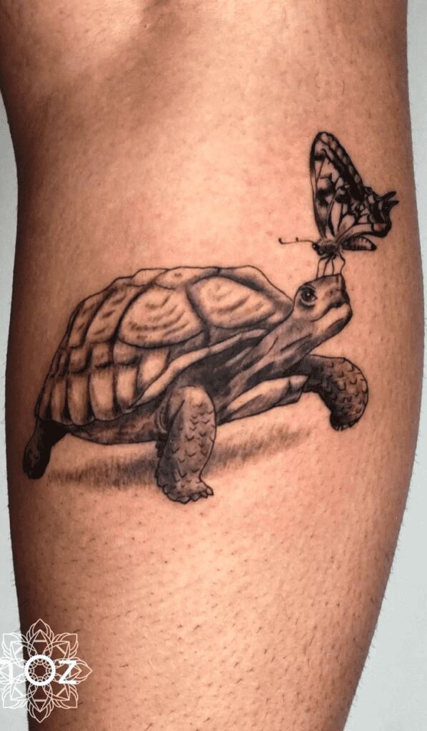 Tattoo of a turtle with a butterfly on its nose, inked on a person's skin, detailed and realistic design.