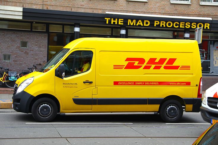 Yellow DHL delivery van parked on a city street, ready for package delivery.