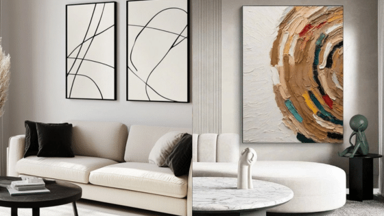 Modern living room with abstract wall art, beige sofas, and black accent pillows showcasing contemporary interior design.