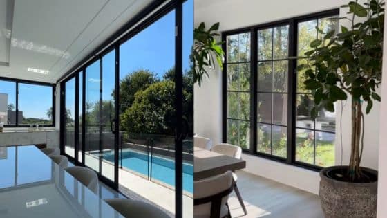 Modern home with large windows overlooking a pool and garden, featuring sleek indoor plants and airy dining area.