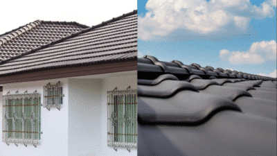 House with a tiled roof and decorative window bars, close-up of roof tiles under a blue sky.