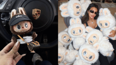 Hand holding a cute plush toy in front of a Porsche steering wheel, woman surrounded by similar plushies.