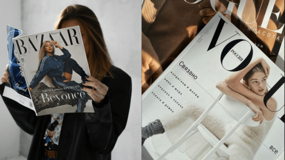 Person reading fashion magazines, including Harper's Bazaar and Vogue, featuring stylish covers.