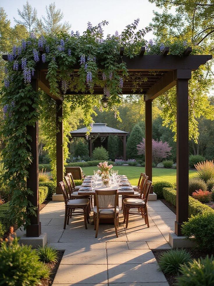 Outdoor dining under a pergola adorned with wisteria, set in a lush garden landscape at sunset.