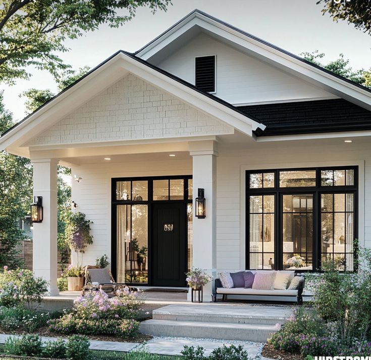 Charming modern white house with a cozy porch and garden. Ideal for suburban living and relaxation.