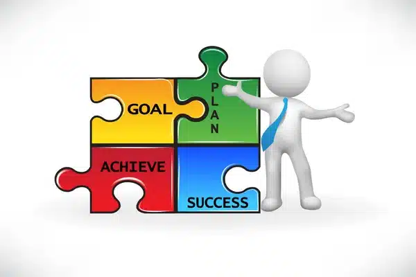 3D figure points at puzzle pieces labeled Goal, Plan, Achieve, Success, symbolizing strategic planning and achievement.