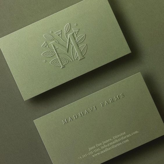 Olive green business cards with embossed tree logo and text for Madhavi Farms.