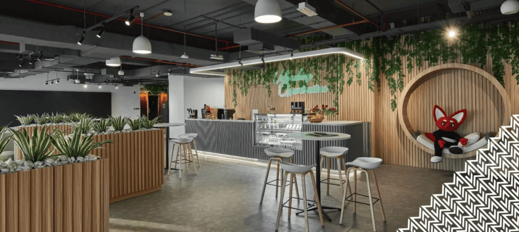 Modern office lounge with wooden decor, plants, and a plush red toy fox in a cozy seating area.