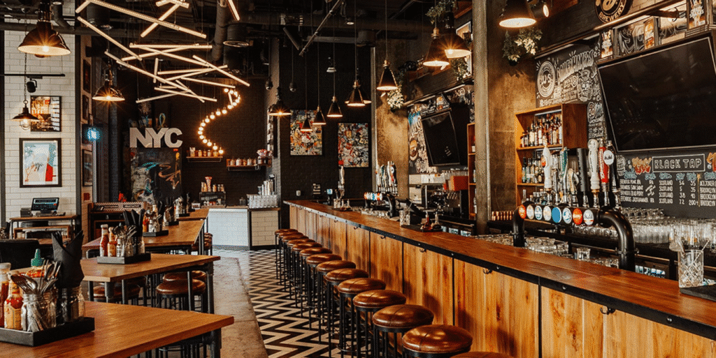Trendy NYC bar interior with wooden counters, modern lighting, and beer taps, creating a cozy and vibrant atmosphere.