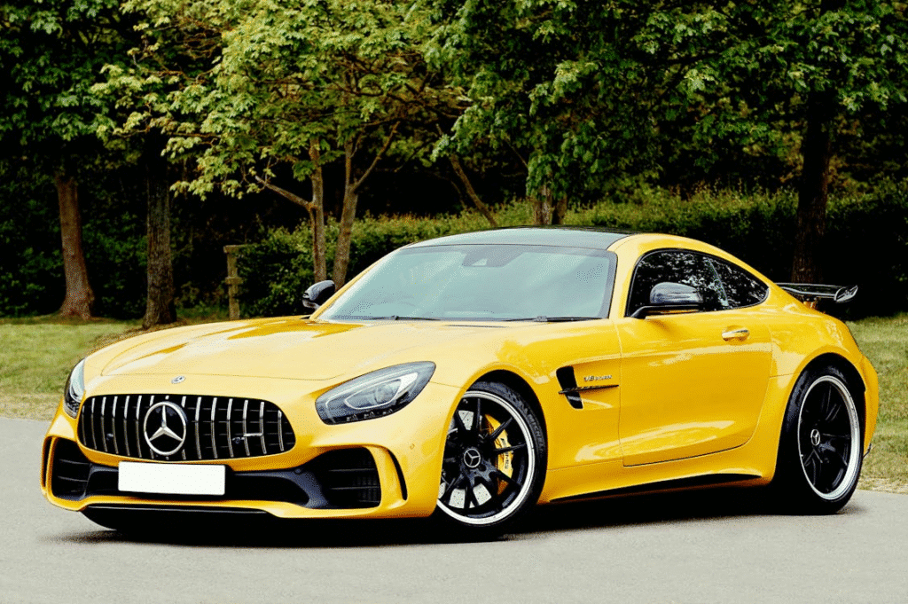 image Yellow luxury sports car parked on a road in a leafy setting. | Sky Rye Design Yellow luxury sports car parked on a road in a leafy setting.