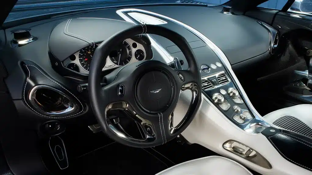 Luxurious car interior with sleek black and silver dashboard, detailed steering wheel, and modern controls.