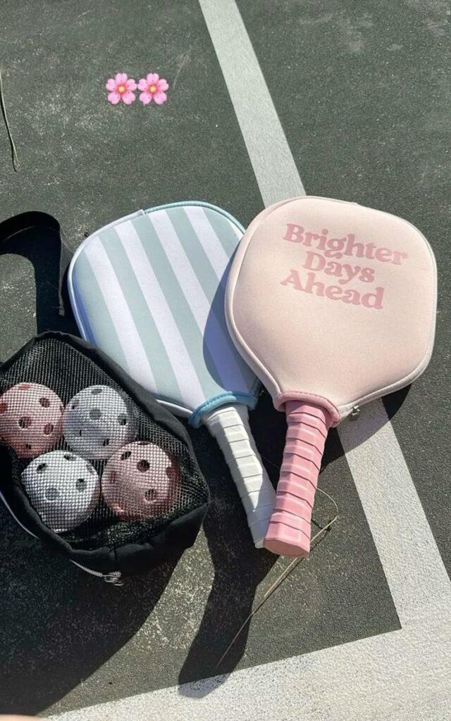Pickleball paddles and balls on a court with Brighter Days Ahead cover, symbolizing optimism and sport.