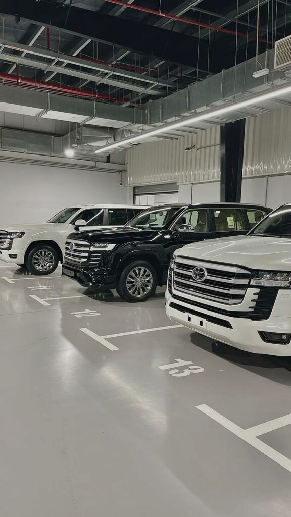Row of parked luxury SUVs in a modern indoor garage, featuring sleek design and polished surfaces.