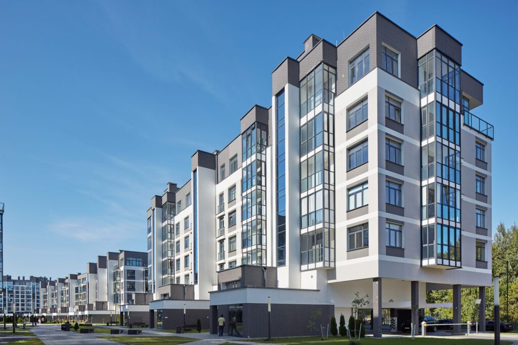 Modern apartment buildings under a clear blue sky, showcasing contemporary architecture and urban living.