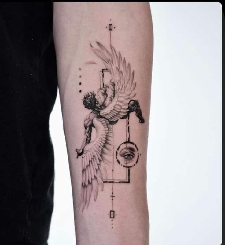 _ Tattoo of a detailed winged figure and eye design on forearm, blending realism and geometric elements. | Sky Rye Design Tattoo of a detailed winged figure and eye design on forearm, blending realism and geometric elements.