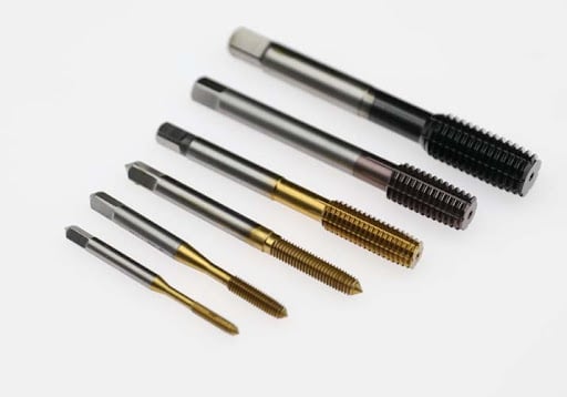 Assorted metal threading taps in varying sizes and colors on a white background.