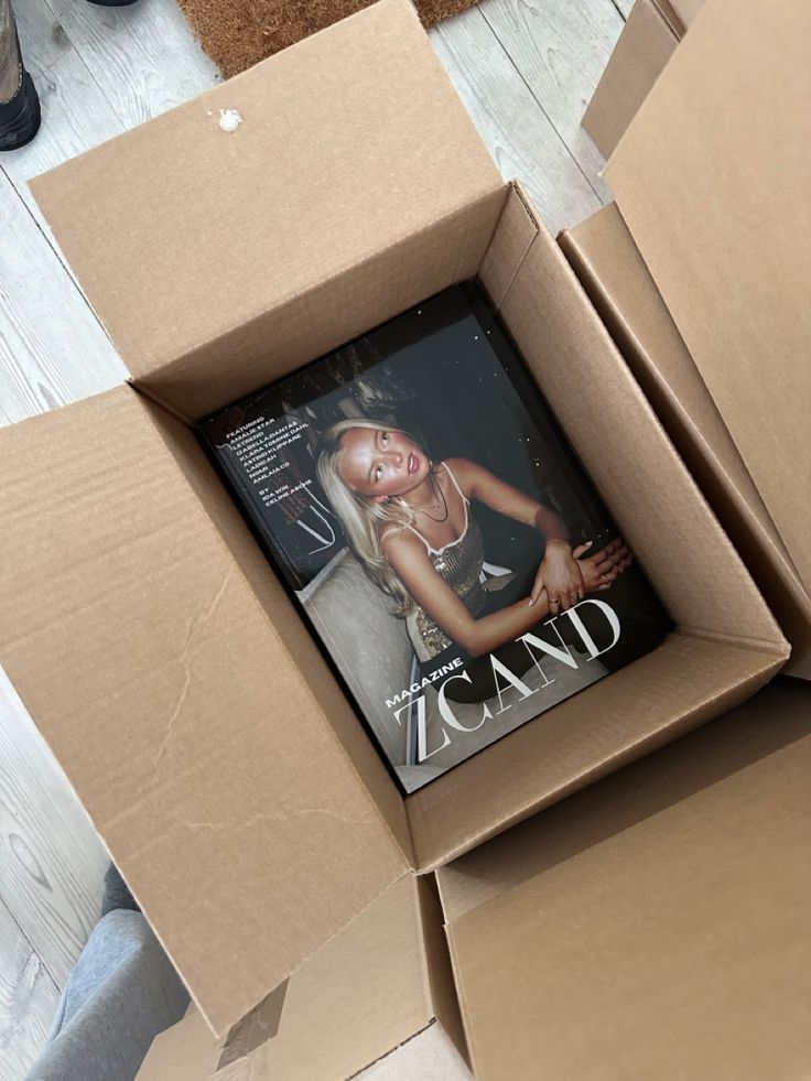 Magazine in a cardboard box, featuring a cover with a fashion model.