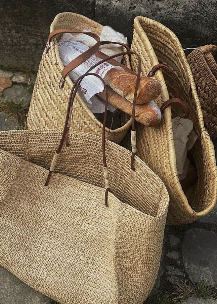 Woven baskets filled with fresh baguettes, set on a stone surface, capturing a rustic, French market vibe.