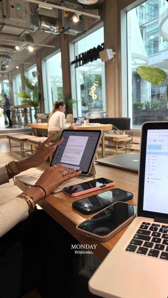 People working in a modern cafe with laptops and tablets, productive workspace atmosphere.