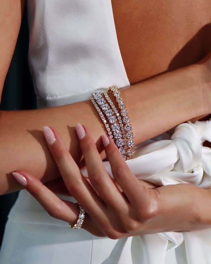 0fbdb194-3ad1-4c77-971c-b4455e608e8c Elegant woman in white dress showcasing sparkling diamond bracelets and ring. | Sky Rye Design Elegant woman in white dress showcasing sparkling diamond bracelets and ring.