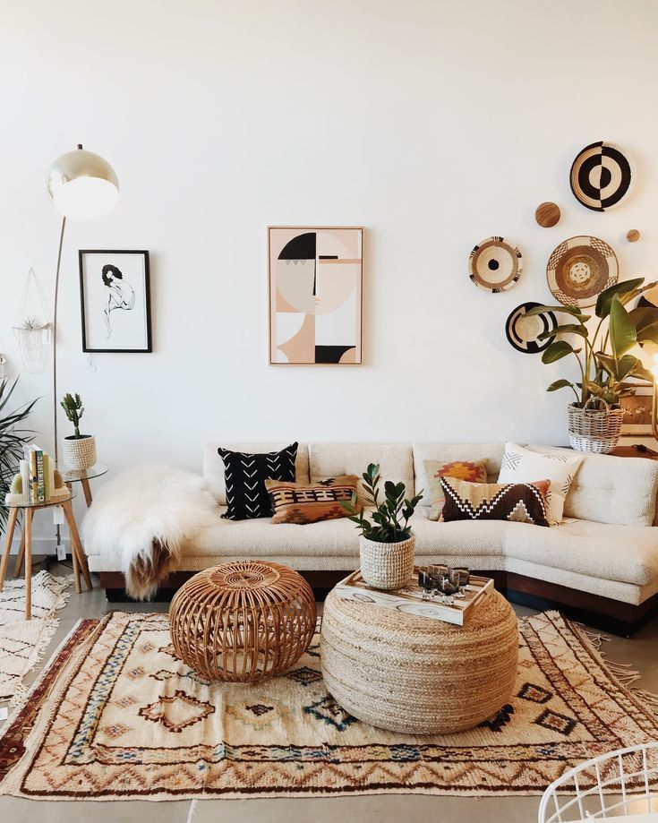 Boho living room with beige sofa, woven decor, plants, and abstract wall art, creating a cozy and stylish atmosphere.