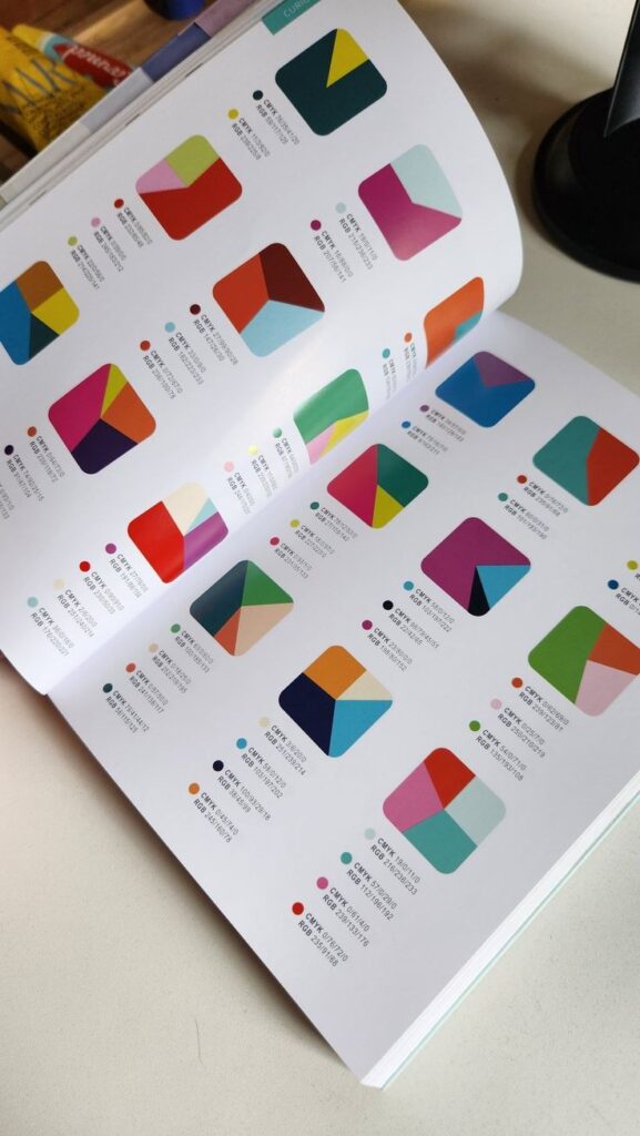 Color palette book displaying vibrant geometric designs with CMYK and RGB codes.