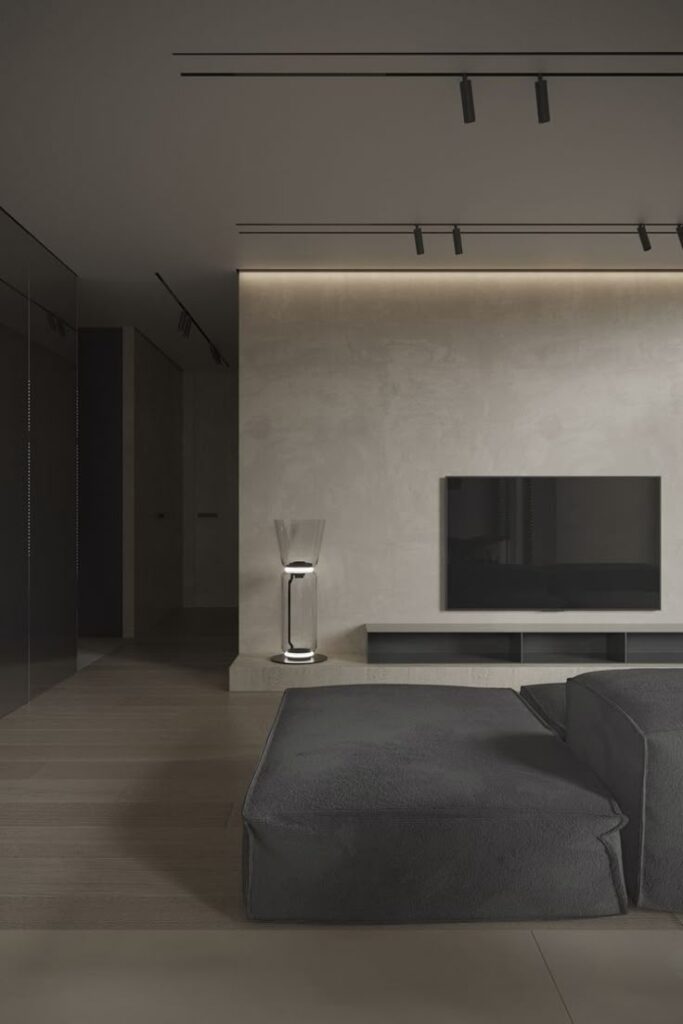 Minimalist living room with modern sofa, sleek TV setup, and ambient lighting on neutral walls. Interior design