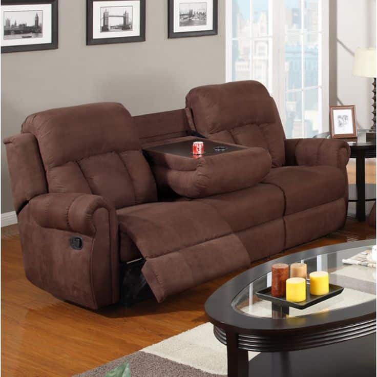 Brown reclining sofa with built-in cupholders in modern living room with framed wall art and coffee table.