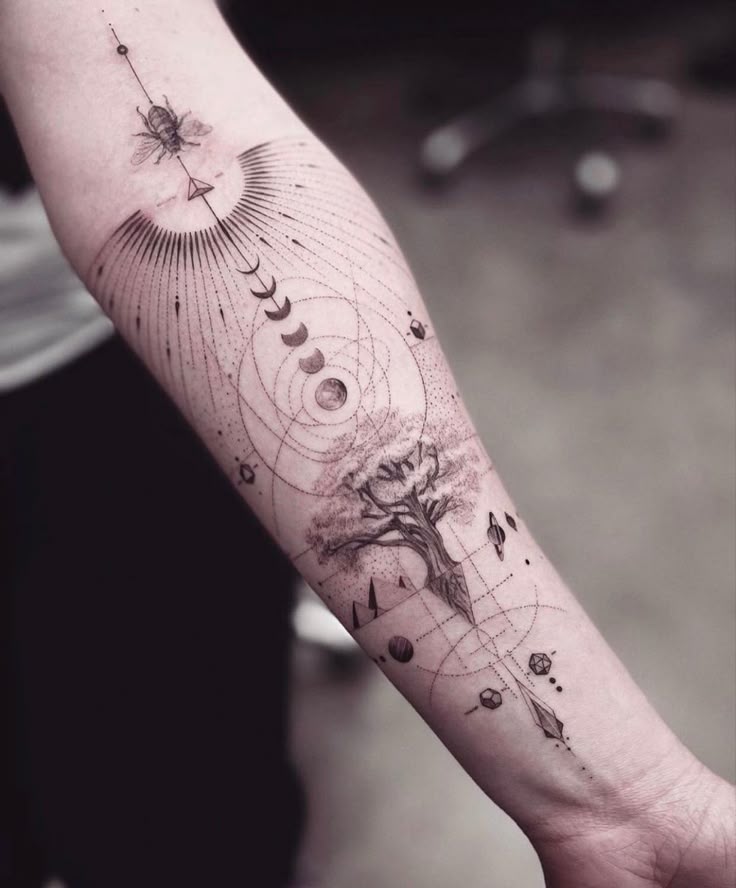 Unique forearm tattoo featuring a tree, lunar phases, and geometric designs for an artistic expression.