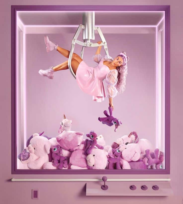 Person in pink dress suspended in claw machine grabbing purple stuffed toy. Surrounded by pink plush animals.
