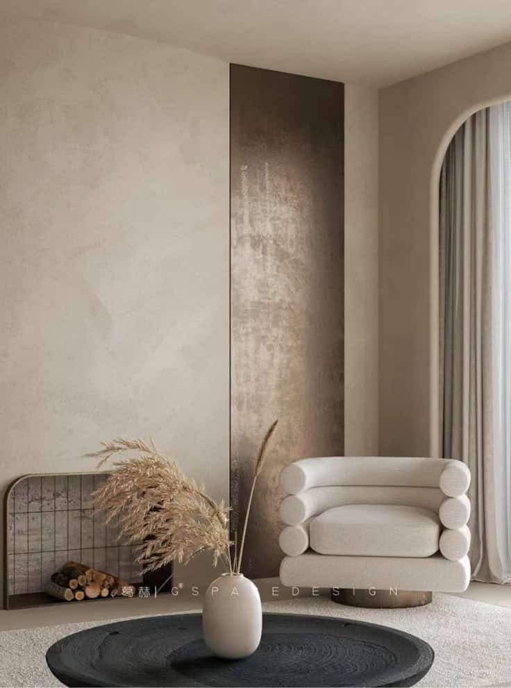 Modern minimalist living room with a round armchair, vase, and decorative panel. Neutral tones create a cozy atmosphere.