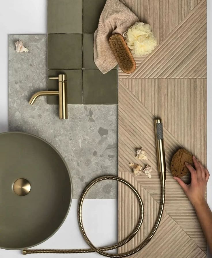 Modern bathroom flat lay with green sink, gold faucet, and textured tiles, featuring bath accessories in natural tones.