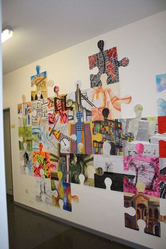 Colorful puzzle piece mural on a wall, showcasing diverse artistic designs and patterns.
