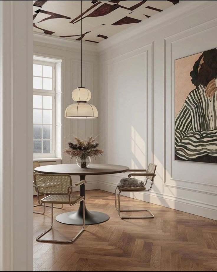 Modern dining room with round table, cane chairs, pendant light, abstract ceiling, and large artwork on the wall.