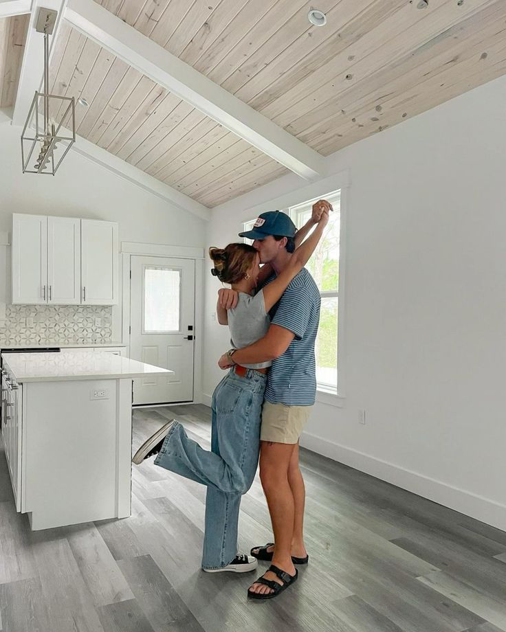 _ 15 Couple embracing in a modern, bright kitchen with wooden ceiling and sleek design elements, expressing joy and love. | Sky Rye Design Couple embracing in a modern, bright kitchen with wooden ceiling and sleek design elements, expressing joy and love.