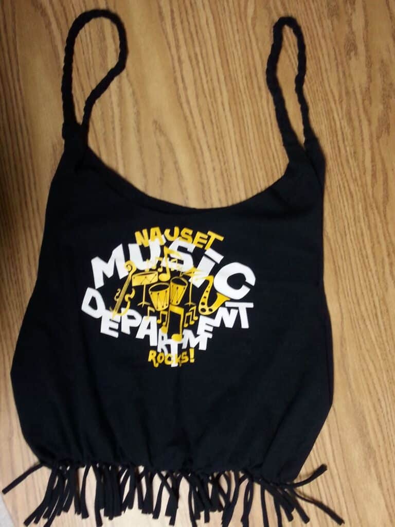 Black tank top with Nauset Music Department Rocks and musical instruments print, laid on a wooden surface.