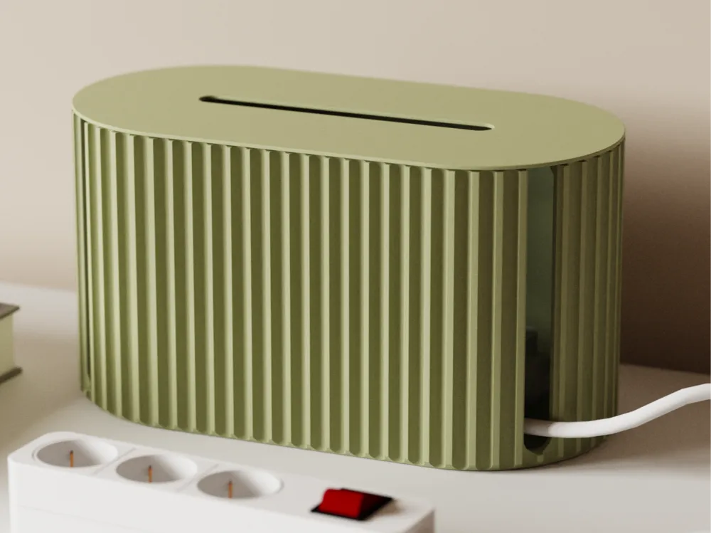Retro-style olive green cable organizer on a desk with a white power strip.