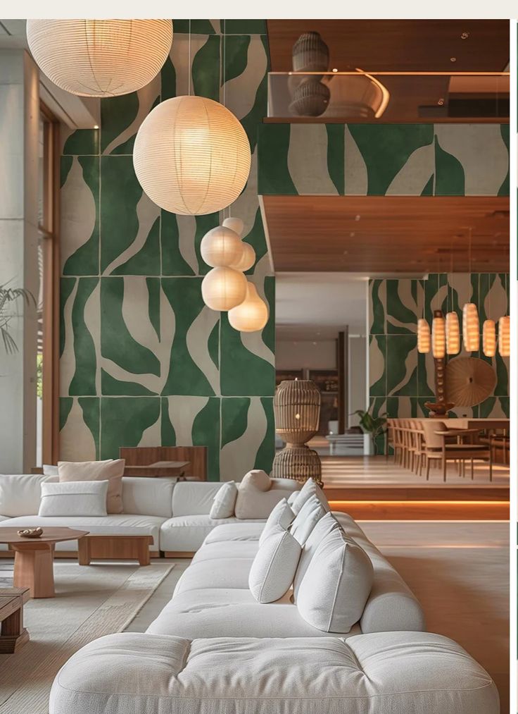 Modern living room with white sectional sofa, round pendant lights, and a bold green abstract wall design.