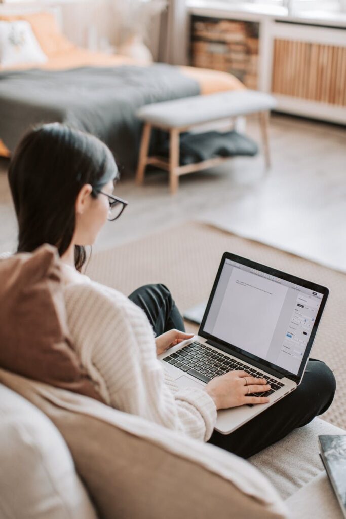 27df0579ef9f0e7ebfa75a6d27e0cb1e Person working on a laptop in a cozy room, focusing on writing or editing a document. | Sky Rye Design Person working on a laptop in a cozy room, focusing on writing or editing a document.