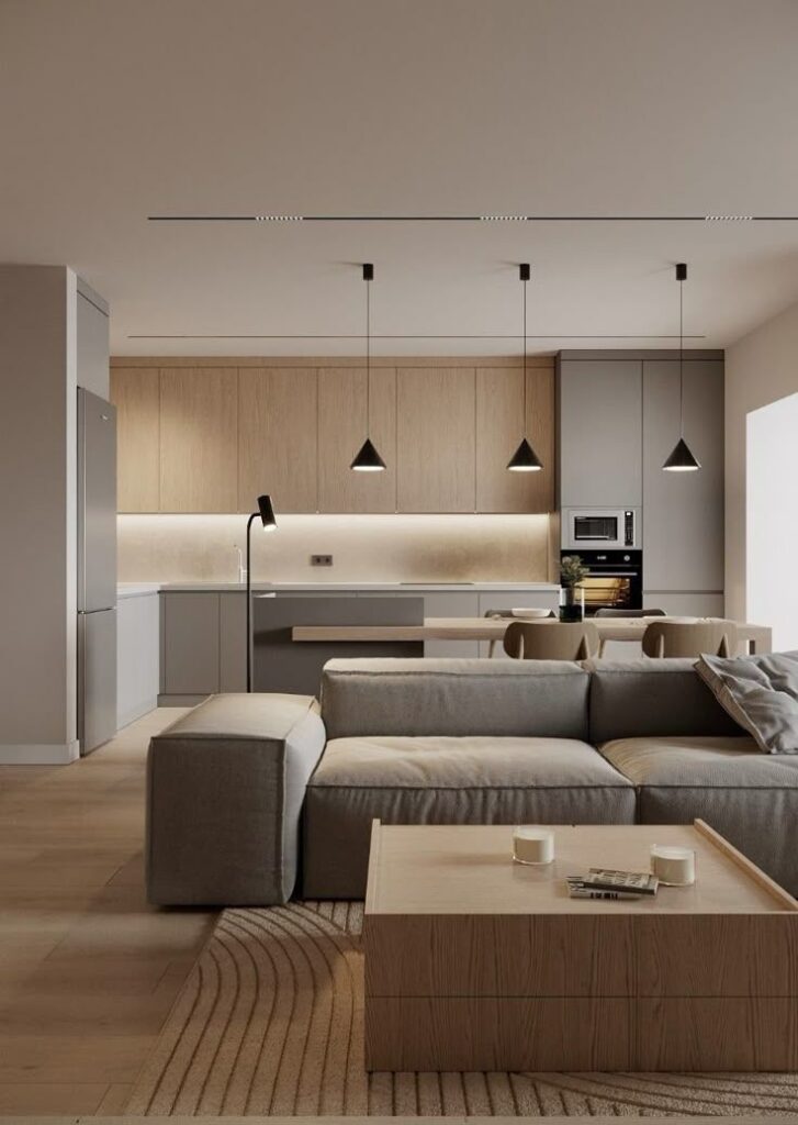 Modern open-concept living room and kitchen with neutral tones, stylish lighting, and sleek furniture.