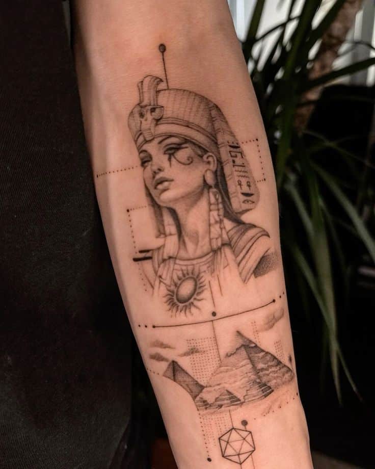 Forearm tattoo of an ancient Egyptian figure with pyramids and geometric designs, styled in black ink.