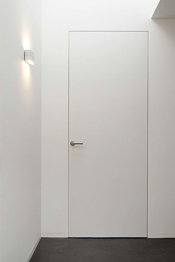 _ 3 Minimalist white door with sleek handle in bright hallway with subtle wall lighting. | Sky Rye Design Minimalist white door with sleek handle in bright hallway with subtle wall lighting.