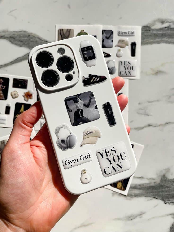 White phone case with motivational and gym-themed stickers, including YES YOU CAN and fitness gear.