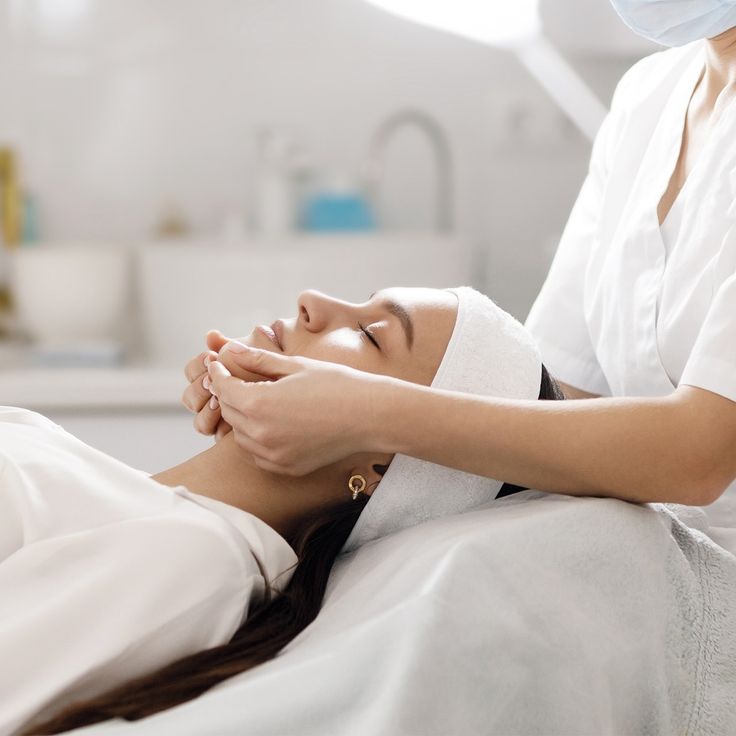 Woman receiving a relaxing facial massage in a spa setting, promoting wellness and skincare treatments.