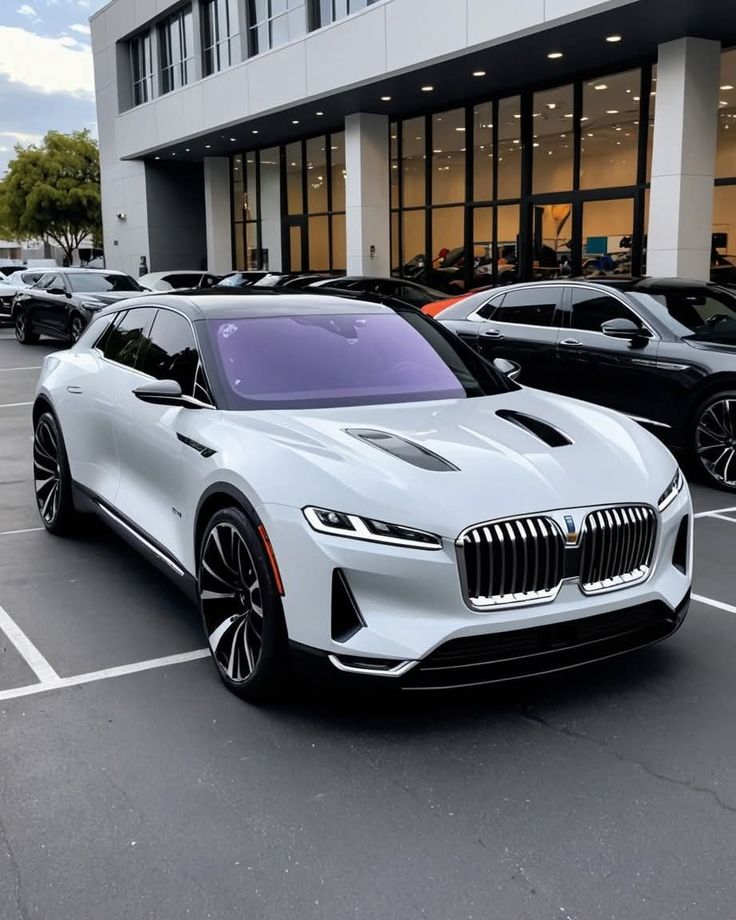 Sleek white luxury car parked at dealership, showcasing modern design and aerodynamic features.