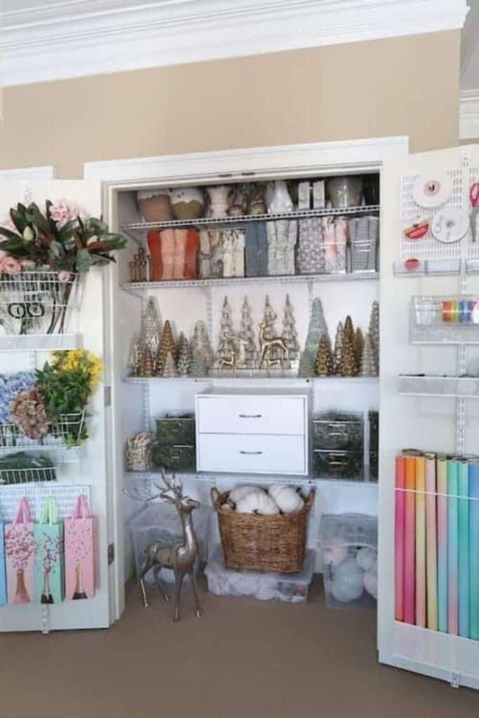 Organized craft closet with floral supplies, holiday decorations, and wrapping paper in vibrant colors.