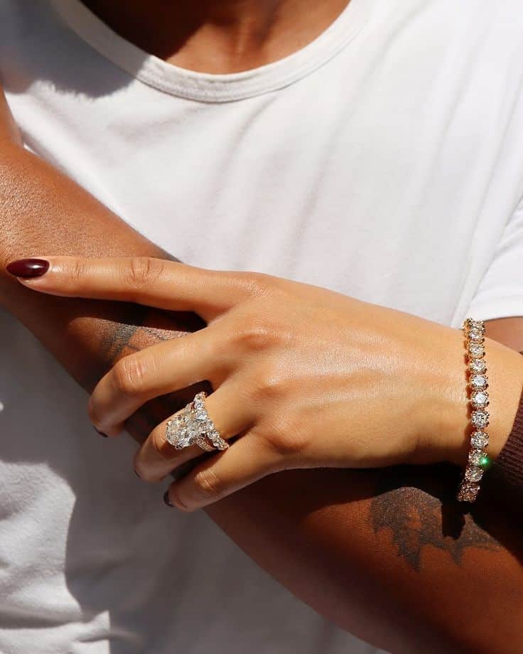 4d14fbce-f63b-4bb8-822d-94e301a6003a Hand with elegant diamond ring and bracelet, gently resting on an arm, showcasing luxury jewelry and style. | Sky Rye Design Hand with elegant diamond ring and bracelet, gently resting on an arm, showcasing luxury jewelry and style.