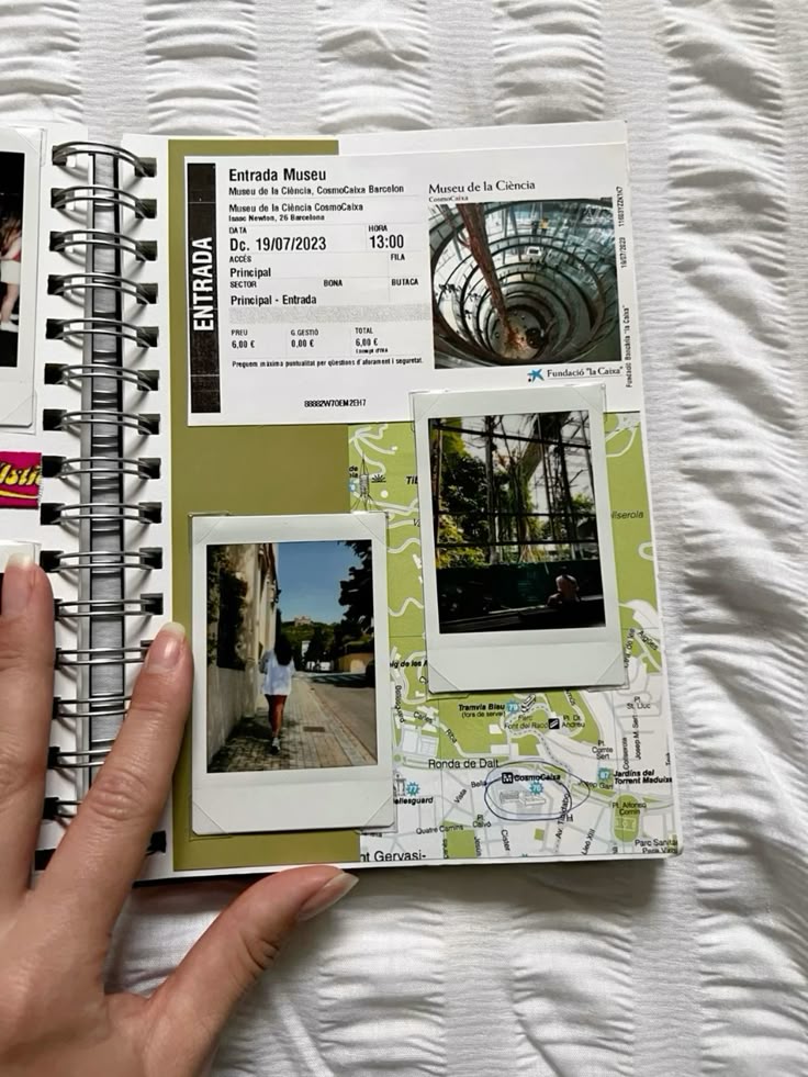 Scrapbook with a museum ticket, two Polaroid photos, and a map background on a spiral-bound page.