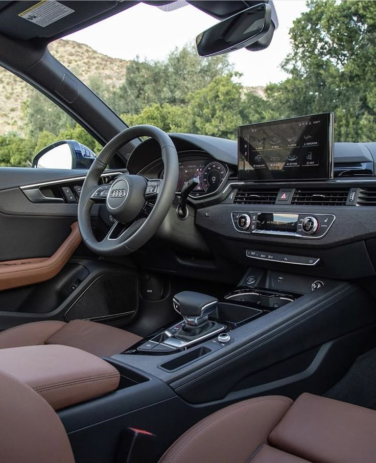 Luxury car interior with leather seats, digital dashboard, and sleek steering wheel, set against a scenic outdoor view.