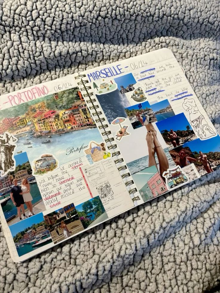 Travel scrapbook open on a fluffy blanket, featuring photos and notes from Portofino and Marseille trips.